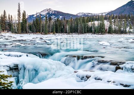 Chutes d'Athabasca à moitié gelées au lever du soleil en hiver Banque D'Images