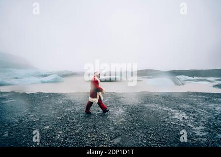 L'Islande, le père Noël marche dans paysage de glacier Banque D'Images