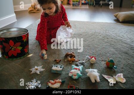 petite fille qui sort des ornements de noël de l'espace de rangement pour couper l'arbre Banque D'Images