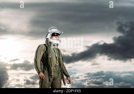 Homme posant vêtu comme un astronaute avec des nuages dans l'arrière-plan Banque D'Images