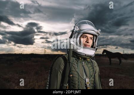 Homme posant vêtu comme un astronaute avec des nuages dans l'arrière-plan Banque D'Images