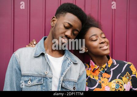 Portrait d'un jeune couple heureux tête à tête avec les yeux fermé Banque D'Images