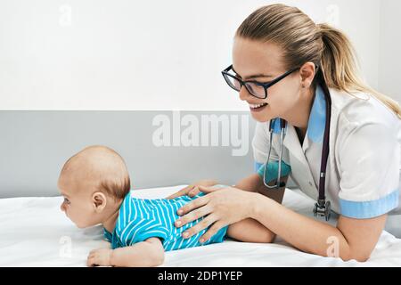 le médecin examine le bébé de 3 mois. Pédiatre souriant communiquer et jouer avec bébé à l'hôpital Banque D'Images