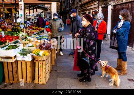 Les gens de la région achètent des fruits et légumes frais à un marché dans la région du pont du Rialto à Venise, en Italie. Banque D'Images