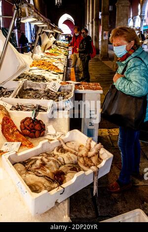 Les gens de la région achètent des fruits de mer frais au marché aux poissons, Venise, Italie. Banque D'Images