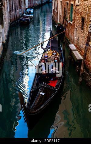 Une famille portant un masque de visage faire UN tour en gondole pendant la pandémie Covid 19, Venise, Italie. Banque D'Images