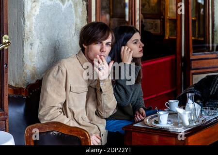 Un jeune couple assis devant Caffe Florian, place Saint-Marc, Venise, Italie. Banque D'Images