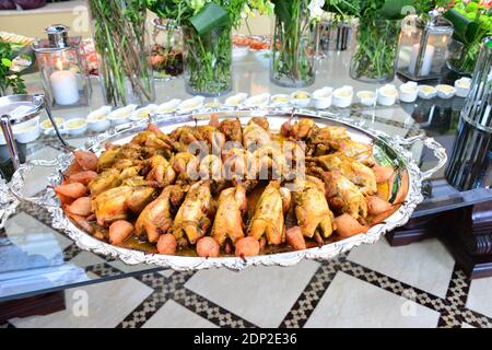 Repas traditionnel marocain farci de poulet avec frites, olives, citron conservé, pain sur la table Banque D'Images