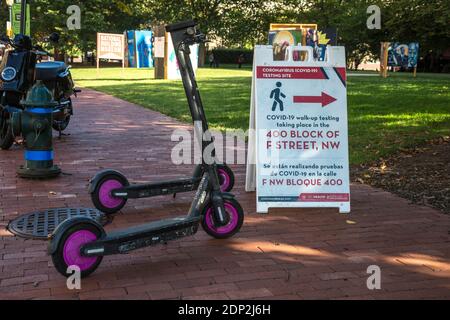 Site d'essai COVID-19 signalisation bilingue et location de scooters électriques, Washington DC, États-Unis, octobre 2020. Banque D'Images