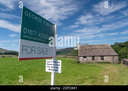 A vendre signe sur petit pâturage et bâtiment dans le Yorkshire Dales, idéal pour la conversion de grange. North Yorkshire, Royaume-Uni. Banque D'Images