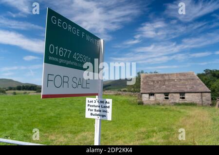 A vendre signe sur petit pâturage et bâtiment dans le Yorkshire Dales, idéal pour la conversion de grange. North Yorkshire, Royaume-Uni. Banque D'Images