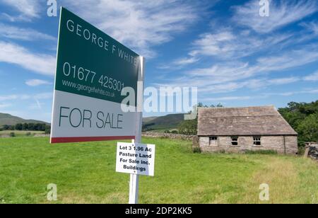 A vendre signe sur petit pâturage et bâtiment dans le Yorkshire Dales, idéal pour la conversion de grange. North Yorkshire, Royaume-Uni. Banque D'Images