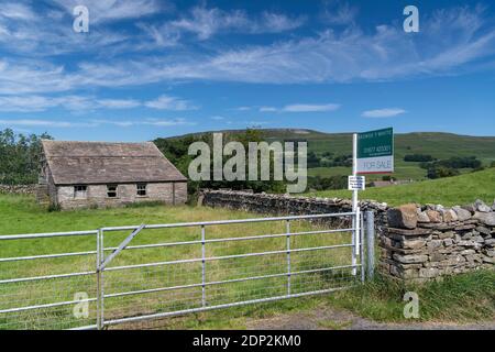 A vendre signe sur petit pâturage et bâtiment dans le Yorkshire Dales, idéal pour la conversion de grange. North Yorkshire, Royaume-Uni. Banque D'Images