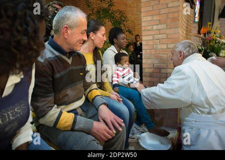 Le pape François lavent les pieds d'une douzaine de détenus pour le jeudi Saint à la prison de Rebibbia à Rome, Italie, le 2 avril 2015. Une des prisonnières, une africaine aux yeux déchirés, a tenu son enfant sur ses genoux et le pape a lavé le pied de l'enfant. Les 12 détenus sélectionnés pour représenter les 2,100 prisonniers étaient originaires d'Italie, du Nigeria, du Congo, de l'Équateur et du Brésil. Le lavage des pieds est un rituel pré-Pâques conçu pour montrer la volonté de servir les autres. François a révolutionné le rite en le faisant également sur les femmes et les non-catholiques, lorsque les règles du Vatican exigent qu'il s'agisse d'une affaire réservée aux hommes Banque D'Images