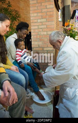 Le pape François lavent les pieds d'une douzaine de détenus pour le jeudi Saint à la prison de Rebibbia à Rome, Italie, le 2 avril 2015. Une des prisonnières, une africaine aux yeux déchirés, a tenu son enfant sur ses genoux et le pape a lavé le pied de l'enfant. Les 12 détenus sélectionnés pour représenter les 2,100 prisonniers étaient originaires d'Italie, du Nigeria, du Congo, de l'Équateur et du Brésil. Le lavage des pieds est un rituel pré-Pâques conçu pour montrer la volonté de servir les autres. François a révolutionné le rite en le faisant également sur les femmes et les non-catholiques, lorsque les règles du Vatican exigent qu'il s'agisse d'une affaire réservée aux hommes Banque D'Images