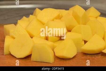 Tranches de pommes de terre sur fond de bois, en cours de cuisson Banque D'Images