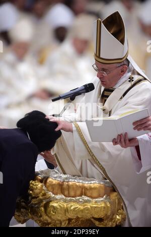 Le pape François baptise Rachel Khayesi, du Kenya, lors de la messe de Pâques à la basilique Saint-Pierre au Vatican le 4 avril 2015. Le pape François a présidé samedi soir la cérémonie solennelle de la Vigile de Pâques dans un climat de préoccupation grandissante du Vatican pour les martyrs chrétiens d'aujourd'hui dont la mort a dominé la saison de Pâques. François a marché dans l'obscurité jusqu'à une basilique Saint-Pierre absolument silencieuse au début de la messe de vigile, qui précède la joyeuse célébration du dimanche de Pâques commémorant la résurrection du Christ après sa crucifixion. Pendant le service de nuit, 10 personnes d'Italie, Portuga Banque D'Images