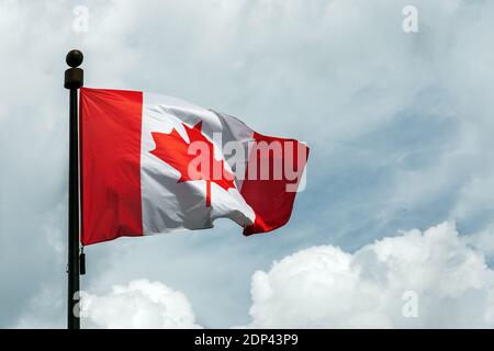 Drapeau du Canada sur le mât flottant dans le ciel Banque D'Images