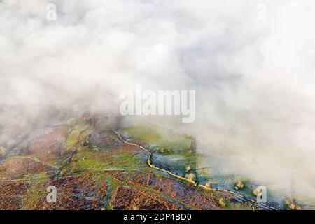 Vue aérienne à travers le brouillard sur un paysage rural gelé et gelé (pays de Galles, Royaume-Uni) Banque D'Images