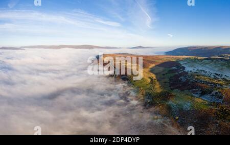 Panorama aérien d'une route de montagne étroite et sinueuse émergeant au-dessus d'une rive de brouillard dans une vallée rurale (pays de Galles) Banque D'Images