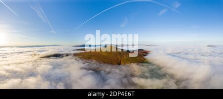 Vue panoramique aérienne d'un sommet de montagne qui s'élève au-dessus d'une mer de nuages bas et de brouillard (Sugar Loaf, pays de Galles). Banque D'Images