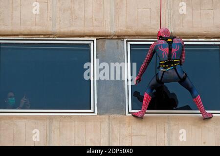 Une femme portant un masque facial est vue en prenant une photo d'un homme vêtu de Spiderman pendant l'événement. La Fondation Andres Olivares, une ONG qui soutient la lutte contre le cancer chez les enfants, a organisé une initiative sociale en coopération avec l’hôpital de la mère et de l’enfant, permettant aux enfants hospitalisés de profiter de la visite du super-héros Spiderman malgré les restrictions imposées par le corornavirus. Banque D'Images