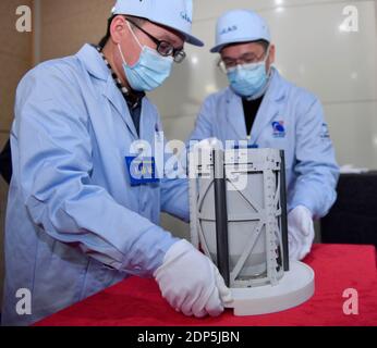 Pékin, Chine. 19 décembre 2020. Les membres du personnel transfèrent le conteneur d'échantillons lunaires lors de la cérémonie de remise des échantillons lunaires Chang'e-5 à l'Administration spatiale nationale de Chine à Beijing, capitale de la Chine, le 19 décembre 2020. Des échantillons de lune prélevés par la sonde Chang'e-5 en Chine ont été transférés samedi matin aux équipes de recherche chinoises. Les scientifiques réaliseront le stockage, l'analyse et la recherche des premiers échantillons du pays prélevés sur l'objet extraterrestre. Credit: Yue Yuewei/Xinhua/Alamy Live News Banque D'Images