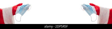 Gros plan sur les mains de Santas tenant des masques médicaux Nouveau concept de réalité normale. Taille de la bannière, espace de copie. Isolé sur fond blanc. Banque D'Images