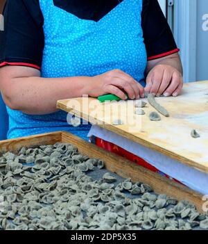 Mains d'une femme qui fait des pâtes italiennes traditionnelles appelées orecchiette grise à partir de pâte de frêne à Bari, Italie Banque D'Images