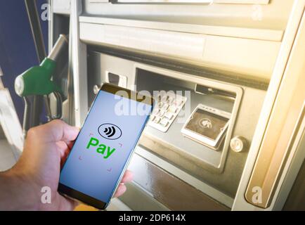 Homme payant du carburant en utilisant un smartphone à la station-service. Concept de paiement sans espèces. Banque D'Images