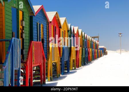 Des cabanes de plage colorées à Muizenberg Cape Town en Afrique du Sud le rivage sur une journée ensoleillée avec ciel bleu et sable Banque D'Images