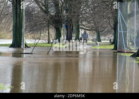 Hereford, Herefordshire - Samedi 19 décembre 2020 - UN homme marche son chien le long des chemins inondés au bord de la rivière à Hereford - la rivière Wye est très haute après plusieurs jours de fortes pluies et devrait culminer à 4,8 m plus tard aujourd'hui. Photo Steven May / Alamy Live News Banque D'Images