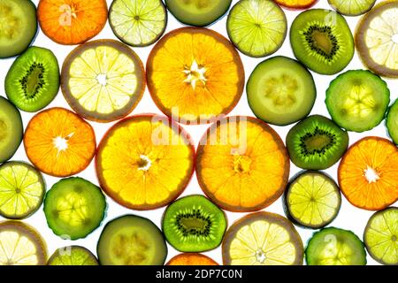 Collage de différentes tranches de fruits orange, manderin, citron, lime, kiwi et légumes concombres et courgettes isolées sur fond blanc avec vue de dessus Banque D'Images