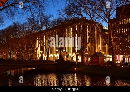 La Königsallee illuminée du centre-ville de Düsseldorf à l'heure de Noël avec un reflet de l'eau dans le canal de la ville. Banque D'Images