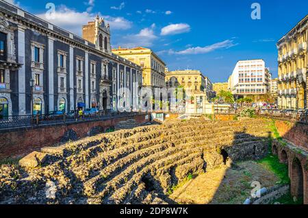 Italie, Catane, 12 mai 2018 : Amphithéâtre romain d'Anfiteatro Romano et Palais Tezzano bâtiment du palais sur la place Piazza Stesicoro à Catane historica Banque D'Images