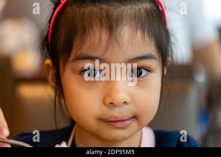 Gros plan d'un enfant asiatique sérieux en regardant l'appareil photo. Joli enfant asiatique avec de grands yeux Banque D'Images