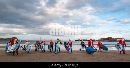 North Berwick, East Lothian, Écosse, Royaume-Uni, 19 décembre 2020. Paddle Boarding Santas pour la charité: Une initiative de la communauté locale par North Berwick News and Views appelée « Christmas Cheer » recueille plus de 5,000 £ de fonds pour les familles dans le besoin. Les paddle-boarders vêtus de costumes de Santa posent pour une photo sur la plage Banque D'Images