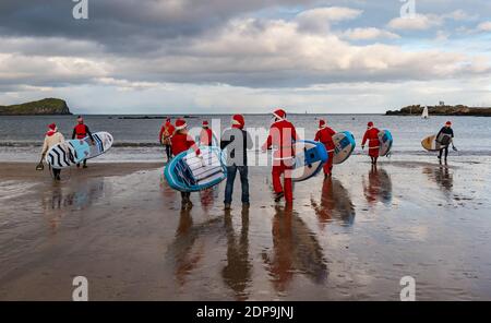 North Berwick, East Lothian, Écosse, Royaume-Uni, 19 décembre 2020. Paddle Boarding Santas pour la charité: Une initiative de la communauté locale par North Berwick News and Views appelée « Christmas Cheer » recueille plus de 5,000 £ de fonds pour les familles dans le besoin. Les paddle boarders habillés en costumes de Santa entrent dans l'eau Banque D'Images