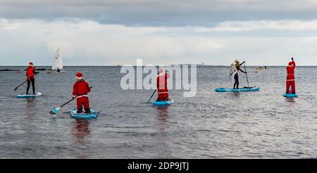 North Berwick, East Lothian, Écosse, Royaume-Uni, 19 décembre 2020. Paddle Boarding Santas pour la charité: Une initiative de la communauté locale par North Berwick News and Views appelée « Christmas Cheer » recueille plus de 5,000 £ de fonds pour les familles dans le besoin. Les paddle boarders sont habillés en costumes de Santa Banque D'Images