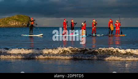 North Berwick, East Lothian, Écosse, Royaume-Uni, 19 décembre 2020. Paddle Boarding Santas pour la charité: Une initiative de la communauté locale par North Berwick News and Views appelée « Christmas Cheer » recueille plus de 5,000 £ de fonds pour les familles dans le besoin. Les paddle boarders sont habillés en costumes de Santa Banque D'Images