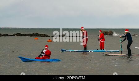 North Berwick, East Lothian, Écosse, Royaume-Uni, 19 décembre 2020. Paddle Boarding Santas pour la charité: Une initiative de la communauté locale par North Berwick News and Views appelée « Christmas Cheer » recueille plus de 5,000 £ de fonds pour les familles dans le besoin. Les paddle boarders sont habillés en costumes de Santa Banque D'Images