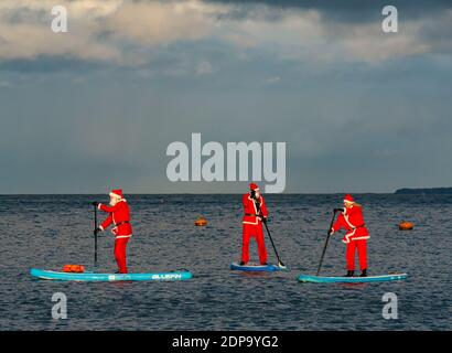 North Berwick, East Lothian, Écosse, Royaume-Uni, 19 décembre 2020. Paddle Boarding Santas pour la charité: Une initiative de la communauté locale par North Berwick News and Views appelée « Christmas Cheer » recueille plus de 5,000 £ de fonds pour les familles dans le besoin. Les paddle boarders sont habillés en costumes de Santa Banque D'Images