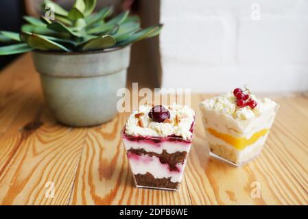 Desserts au cheesecake dans des verres, baies fraîches, fromage à la crème et biscuits digestifs desserts dans des verres Banque D'Images