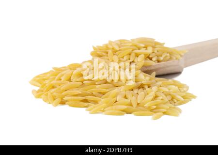 En Grèce appelé kritharaki. En Italie appelé Orzo. Pâtes en forme de riz dans une cuillère en bois isolée sur fond blanc. Type de pâtes. Ingrédient alimentaire. Banque D'Images