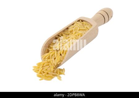 En Grèce appelé kritharaki. En Italie appelé Orzo. Pâtes en forme de riz dans une cuillère en bois isolée sur fond blanc. Type de pâtes. Ingrédient alimentaire. Banque D'Images