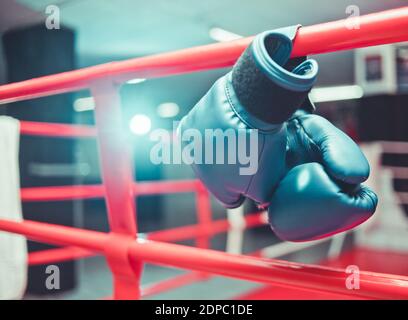 Paire de gants de boxe bleus accroché à l'anneau Banque D'Images
