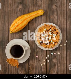 Vue de dessus d'une assiette de gaufres croustillantes, d'une tasse de café et de courge sur une table Banque D'Images