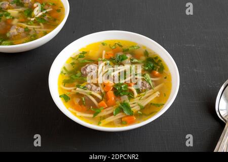 Maison Sopa a la minuta dans des bols blancs sur fond noir, vue en angle bas. Banque D'Images