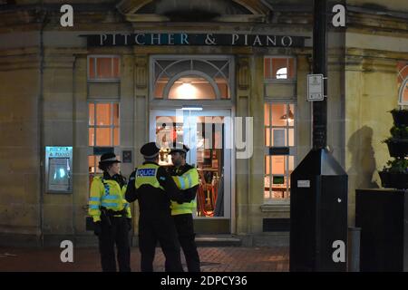 Poste de police britannique des transports devant Pitcher & Piano on duty parlant à Reading Town. Banque D'Images