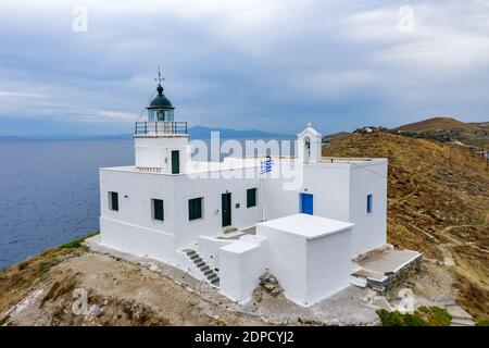 Grèce, île de Kea Tzia. Vue aérienne du phare et des toits blancs de l'église Saint-Nicolas sur un cap rocheux, ciel bleu clair et fond d'eau de mer Banque D'Images